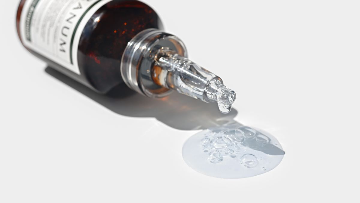 Veranum Cicazulene Balancing Ampoule tipped on its side with clear calming liquid pooling on a white surface